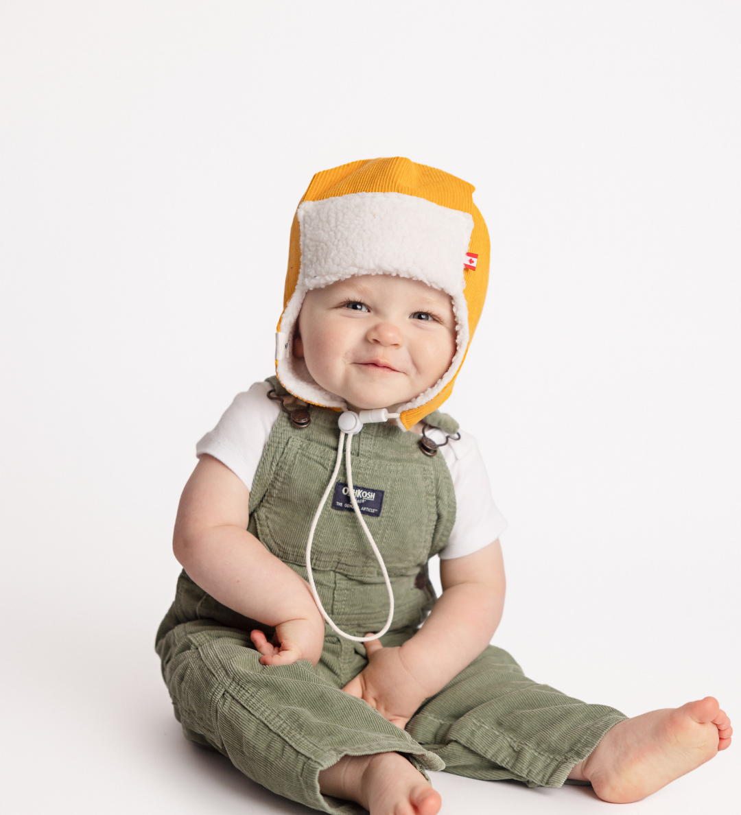 Mustard yellow corduroy baby pilot hat with sherpa lining and chin strap, side view, Made in Canada