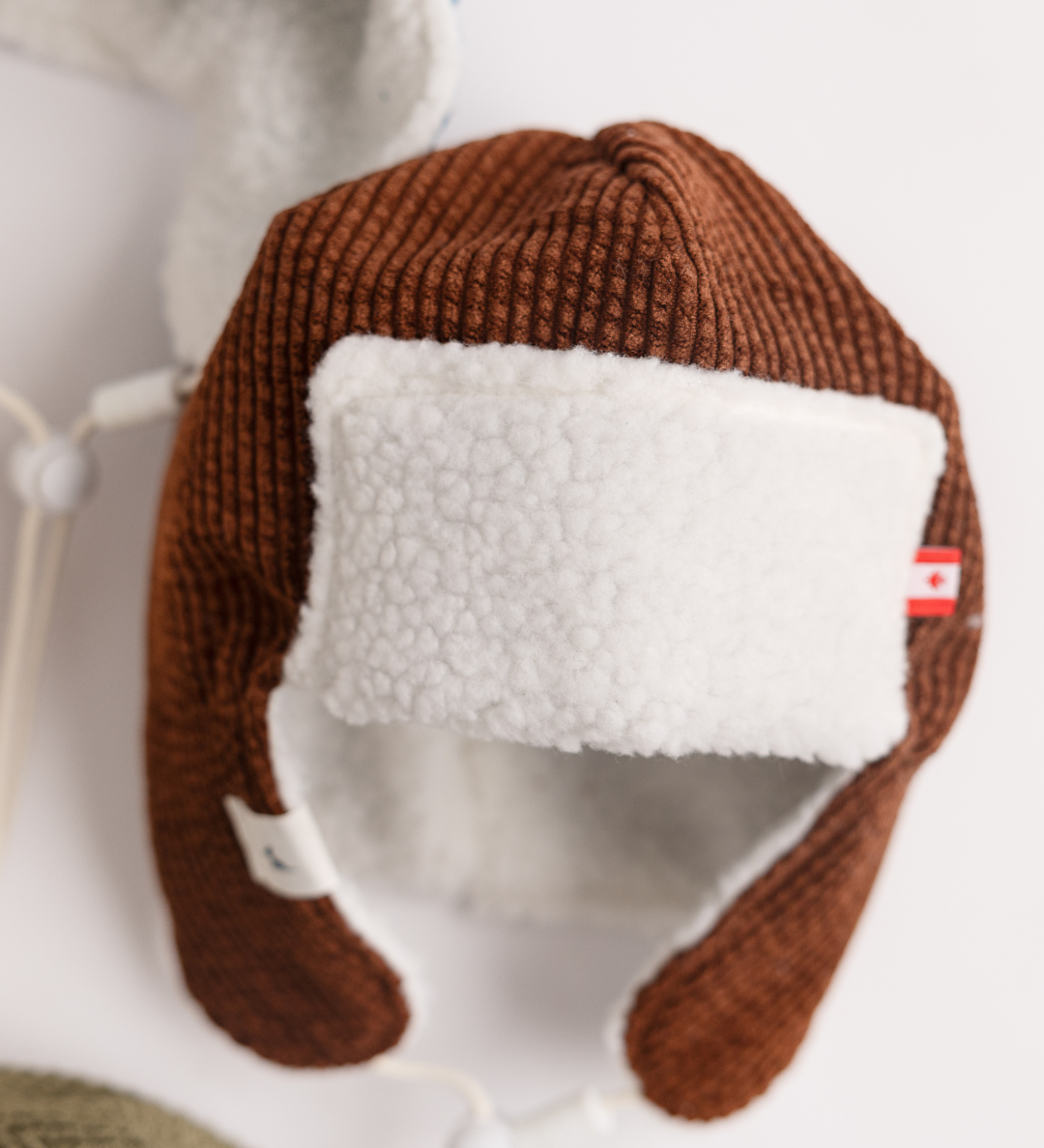 Brown corduroy baby pilot hat with sherpa lining and chin strap, side view, Made in Canada