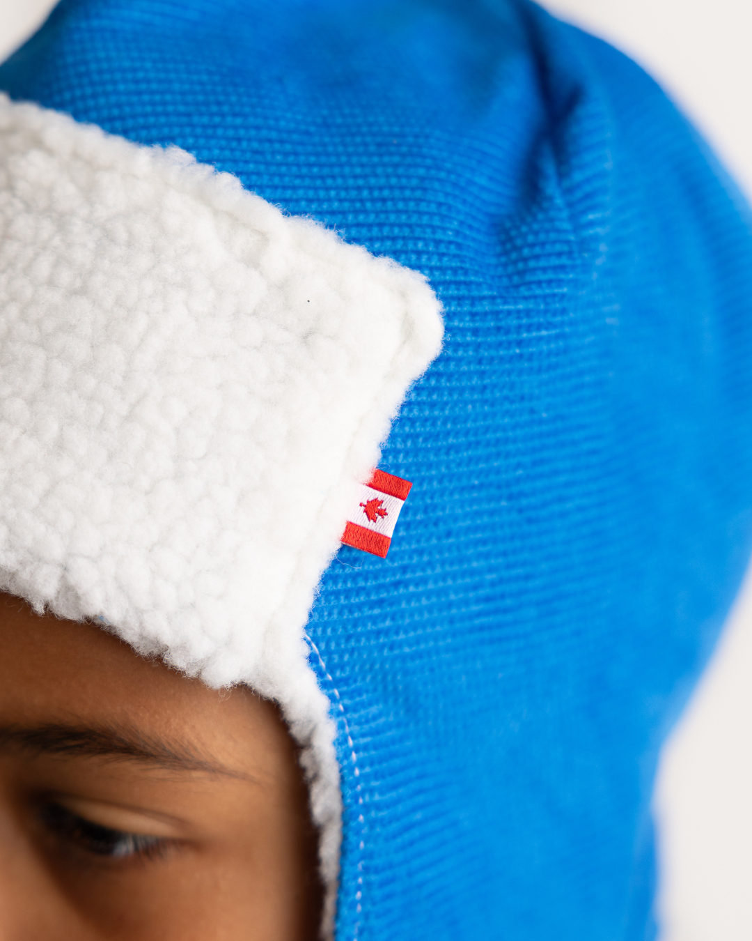 Newbornlander Royal Blue Corduroy Pilot Hat product photo on mannequin, Canada flag tag detail