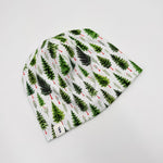 Newbornlander Christmas Pine beanie hat for babies, white cotton with watercolour evergreen trees and red berries, side view